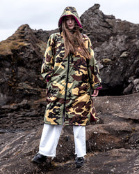 Woman stood in front of rocks, wearing Camo Pink dryrobe® Advance Long Sleeve