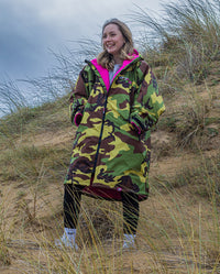 Girl stood in sand dunes wearing Camo Pink dryrobe® Advance Kids Long Sleeve