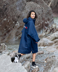 Boy walking through rock pools wearing Navy Grey dryrobe® Advance Kids Long Sleeve