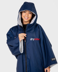 Girl smiling wearing Kids dryrobe Advance Short Sleeve change robe in Navy Grey with hood up