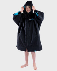 Boy wearing Black Blue dryrobe® Advance Kids Short Sleeve changing robe zipped with hood up