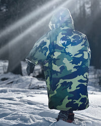 Boy walking through snow with back to the camera, wearing dryrobe Advance Short Sleeve changing robe in Camo Grey