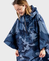 Girl smiling looking down, wearing Blue Camo Kids dryrobe® Waterproof Poncho