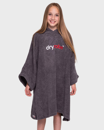 Girl smiling wearing Kids Towel Robe in Slate Grey with hood down