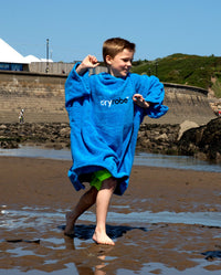 Boy running on beach wearing Cobalt Blue Kids Organic Towel robe