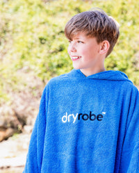 Boy smiling wearing Cobalt Blue Kids Organic Towel robe