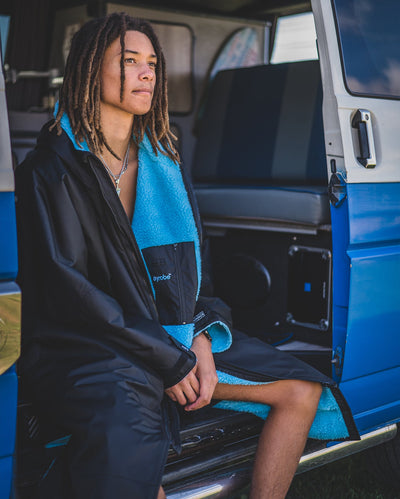 *MALE* sitting in a van, wearing Black Blue dryrobe® Advance Long Sleeve