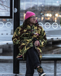 *MALE* sitting on in a bus stop wearing Camo Pink dryrobe® Advance Long Sleeve