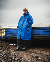 *MALE* leaning on a boat wearing Cobalt Blue Black dryrobe® Advance Long Sleeve