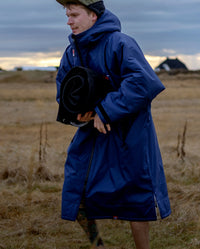 *MALE* walking through field, wearing Navy Grey dryrobe® Advance Long Sleeve, 