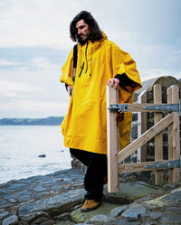 *MALE* walking through a gate wearing  Yellow dryrobe® Waterproof Poncho