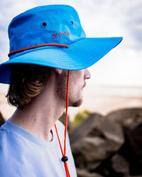 *MALE* Man looking out to sea, wearing dryrobe Quick Dry Brim Hat in Blue 