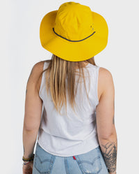 Woman with back to the camera wearing dryrobe Quick Dry Brimmed Hat in Yellow