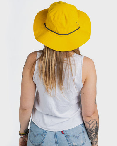 Woman with back to the camera wearing dryrobe Quick Dry Brimmed Hat in Yellow